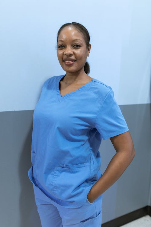 a nurse standing and smiling in a hospital